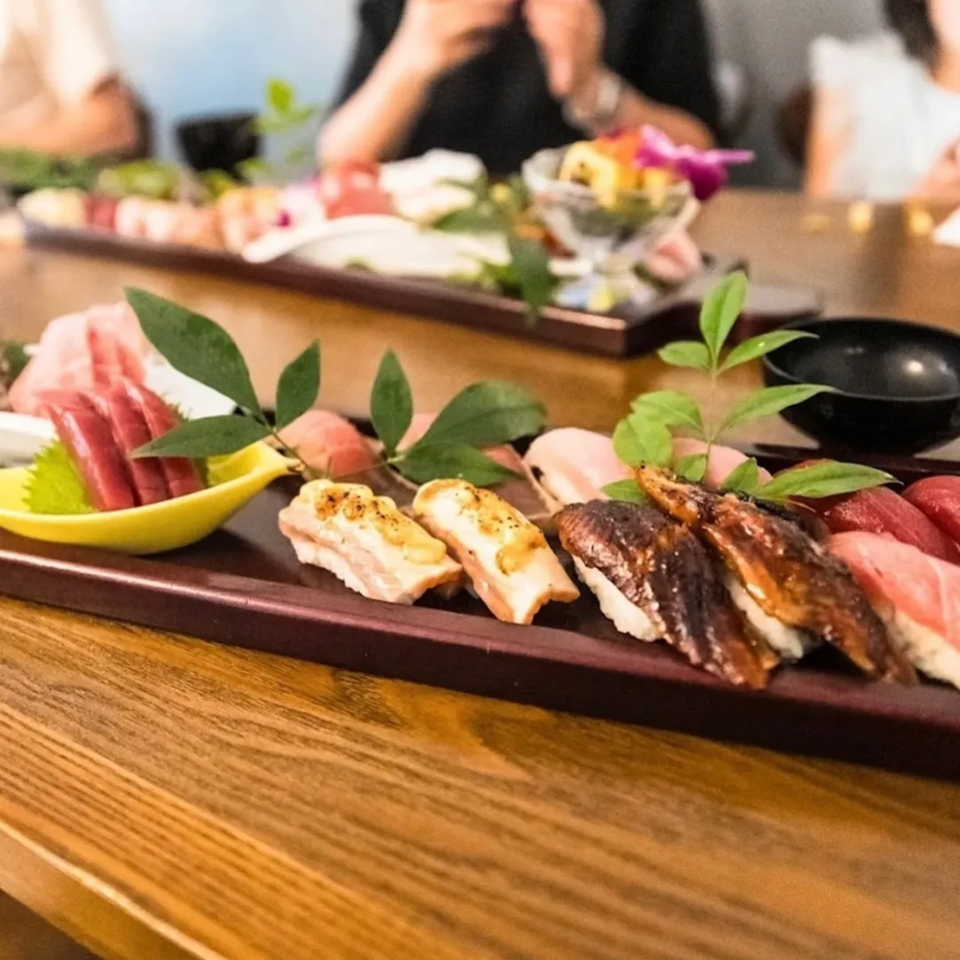 A wooden platter of various sushi and sashimi, including tuna, salmon, and eel, at Ko Japanese Dining.